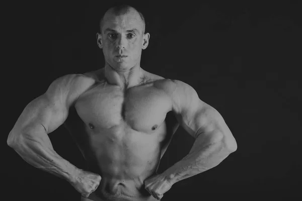 Handsome power athletic man in training pumping up muscles with — Stock Photo, Image