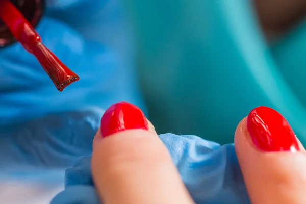 Kobieta w salon paznokci, otrzymujących manicure przez kosmetyczkę. zbliżenie ręka spoczywa na biały tovel — Zdjęcie stockowe