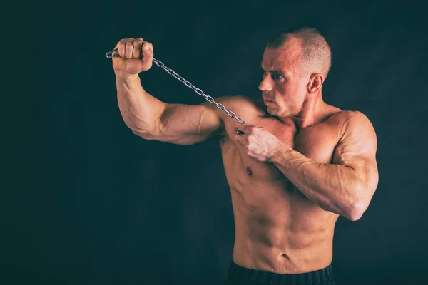 Musculoso, cuerpo de alivio culturista sobre un fondo negro. Negro a — Foto de Stock