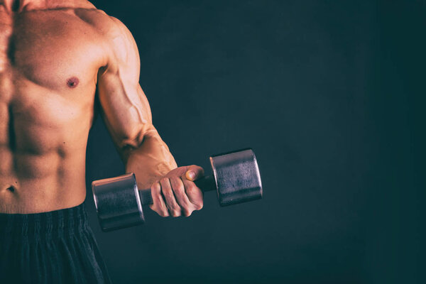 Muscular, relief body bodybuilder on a black background. Black a