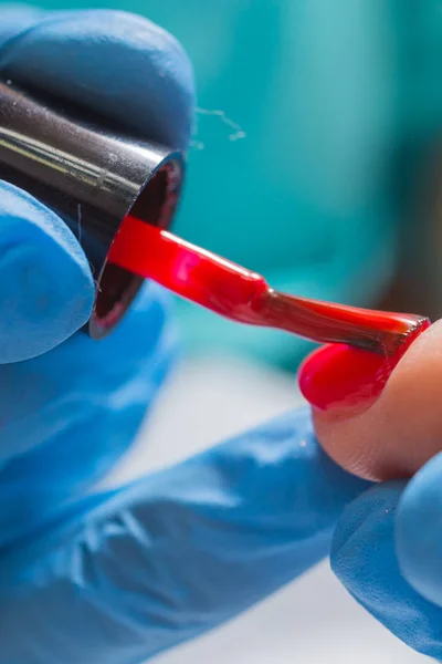 Donna in salone di bellezza che riceve la manicure da estetista. primo piano della mano femminile appoggiata su una paletta bianca — Foto Stock