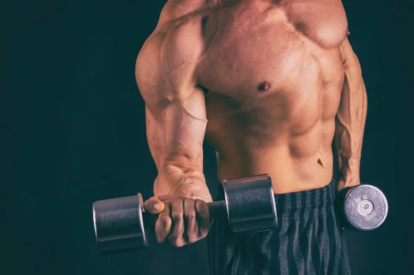 Muscular, fisiculturista alívio em um fundo preto. Preto a — Fotografia de Stock