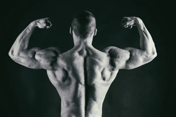 Potenza maschile fitness su uno sfondo nero — Foto Stock