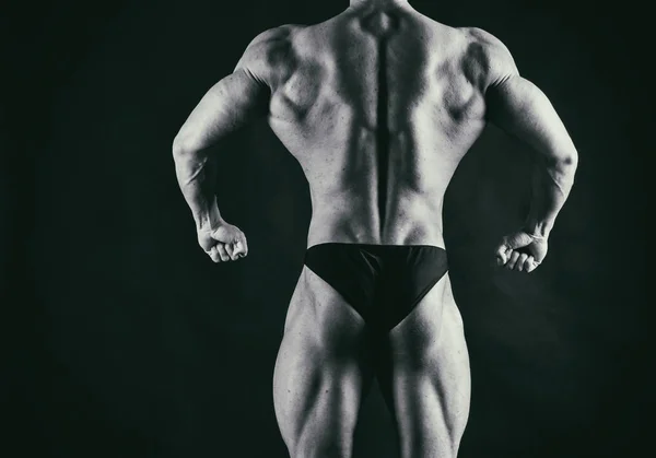 Male power fitness on a black background — Stock Photo, Image