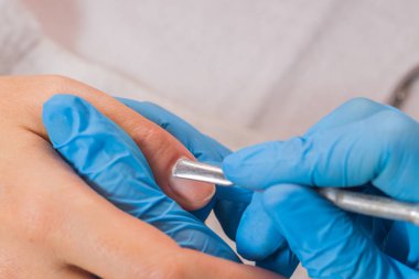 Tırnak salonu manikür güzellik uzmanı tarafından alan kadın. closeup el üzerinde beyaz tovel dinlenme