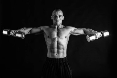 Bir adam siyah bir zemin üzerine muhteşem bir kas vücut ile