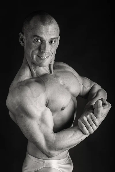 Schöner Bodybuilder auf schwarzem Hintergrund — Stockfoto