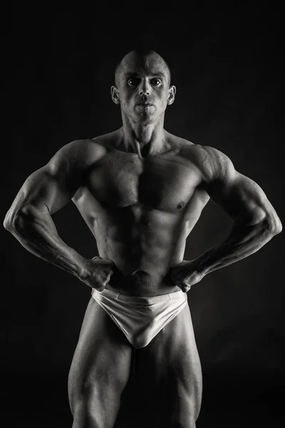 Mooie bodybuilder op een zwarte achtergrond — Stockfoto