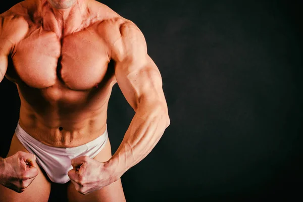 Mooie bodybuilder op een zwarte achtergrond — Stockfoto