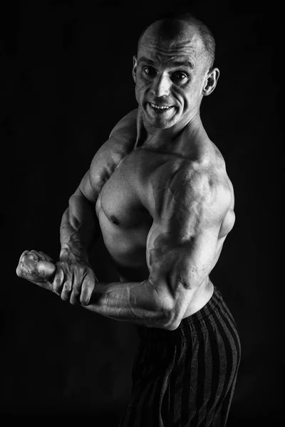 一个华丽的肌肉发达的身体在黑色背景上的男人 — 图库照片