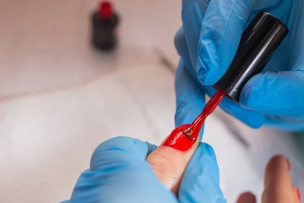 Woman in nail salon receiving manicure by beautician. closeup of female hand resting on white tovel — Stock Photo, Image