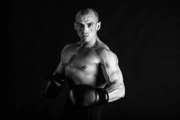 Un hombre con un cuerpo musculoso magnífico sobre un fondo negro —  Fotos de Stock