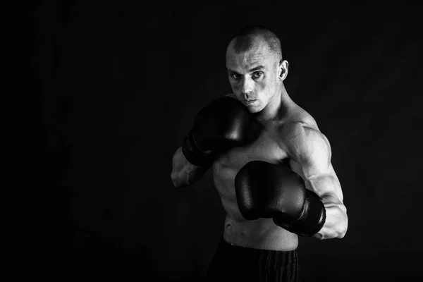Un uomo con un corpo muscoloso splendido su uno sfondo nero — Foto Stock