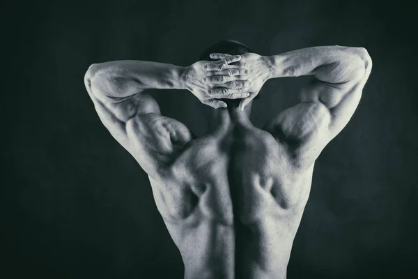 Muscoloso corpo maschile su uno sfondo nero — Foto Stock