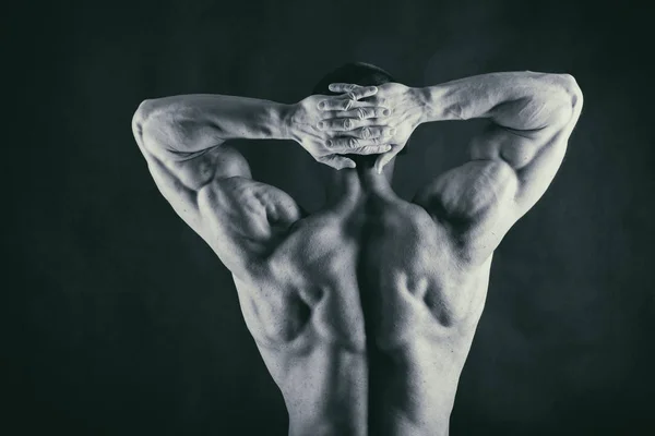 Corpo masculino muscular em um fundo preto — Fotografia de Stock