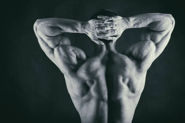 Muscoloso corpo maschile su uno sfondo nero — Foto Stock
