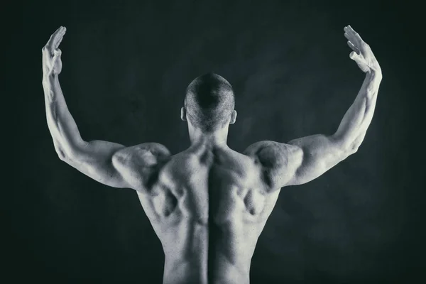 Corpo masculino muscular em um fundo preto — Fotografia de Stock