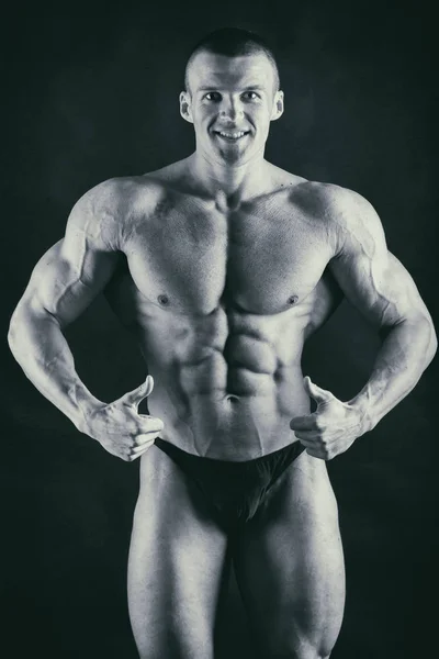 Cuerpo masculino muscular sobre un fondo negro — Foto de Stock