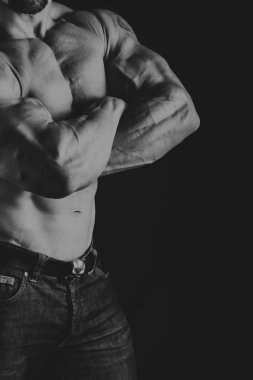 Bir adam siyah bir zemin üzerine muhteşem bir kas vücut ile