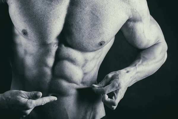 Cuerpo masculino muscular sobre un fondo negro —  Fotos de Stock