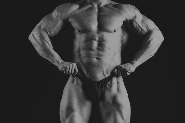 Un homme avec un corps musclé magnifique sur un fond noir — Photo