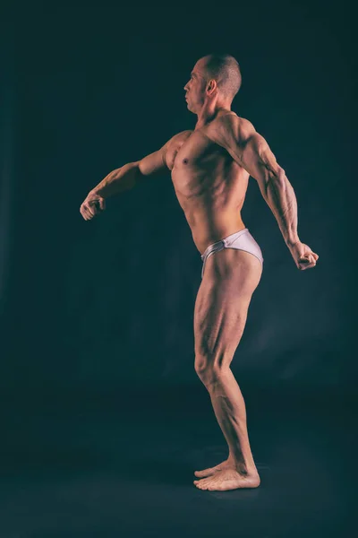 Culturista posando en diferentes poses demostrando su músculo —  Fotos de Stock