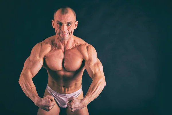 Bodybuilder posing in different poses demonstrating their muscle — Stock Photo, Image