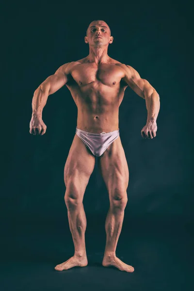 Бодібілдер позує в різних позах, демонструючи свої м'язи — стокове фото