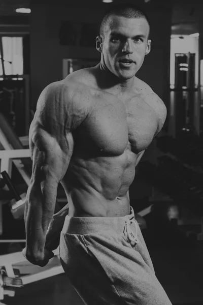 El hombre está ocupado con pesas en el gimnasio. —  Fotos de Stock