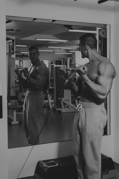 Az ember foglalkozik a súlyokat, az edzőteremben — Stock Fotó