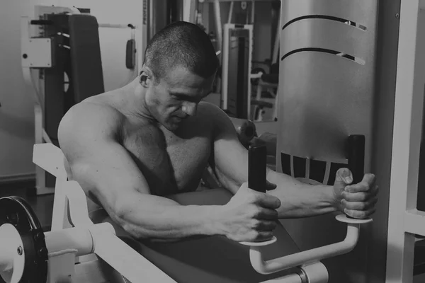 El hombre está ocupado con pesas en el gimnasio. — Foto de Stock