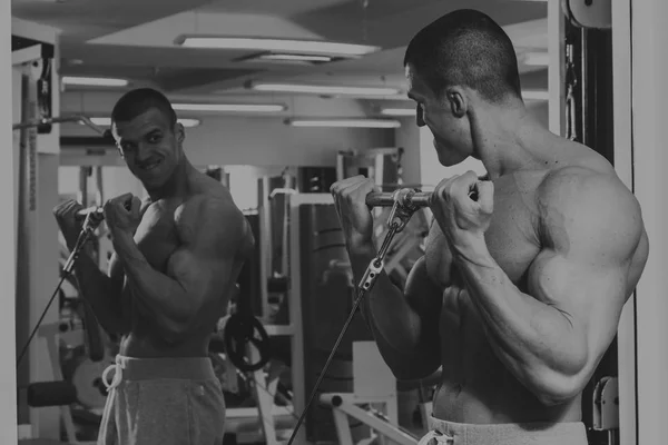 El hombre está ocupado con pesas en el gimnasio. — Foto de Stock