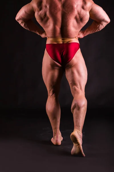 Бодібілдер позує в різних позах, демонструючи свої м'язи — стокове фото