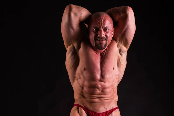 Fisiculturista posando em diferentes poses demonstrando seu músculo — Fotografia de Stock