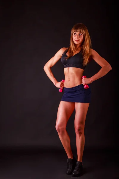 Atletische meisje op een donkere achtergrond. — Stockfoto