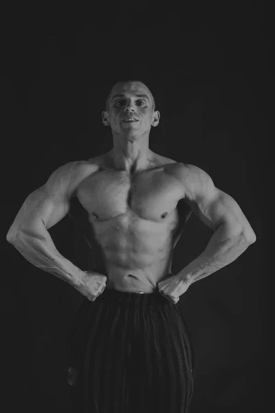 Man with dumbbells on a black and white photo. — Stock Photo, Image