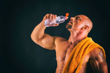 Karanlık bir arka plan üzerinde büyük vücut geliştirmeci.