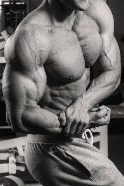 Spor salonunda egzersiz yapan kaslı vücut geliştirmeci adam