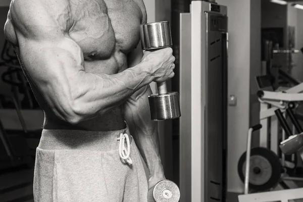 Muscular culturista chico haciendo ejercicios en el gimnasio — Foto de Stock