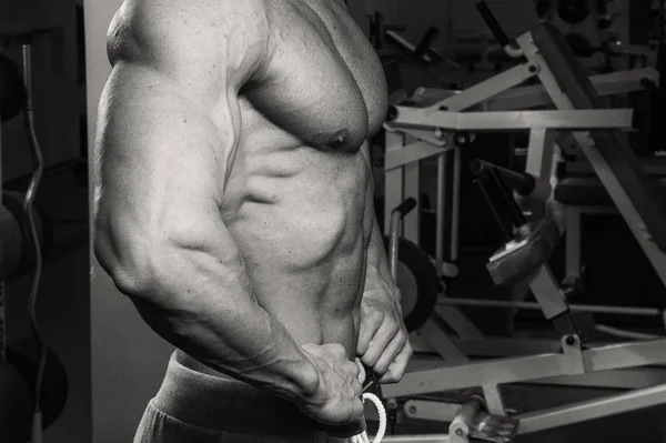 Muscular bodybuilder guy doing exercises in gym — Stock Photo, Image