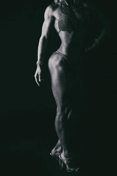 Elegant training, muscular woman on a black background — Stock Photo, Image