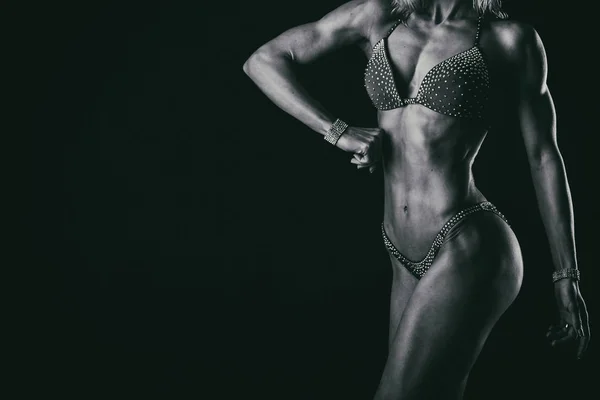 Elegantes Training, muskulöse Frau auf schwarzem Hintergrund — Stockfoto