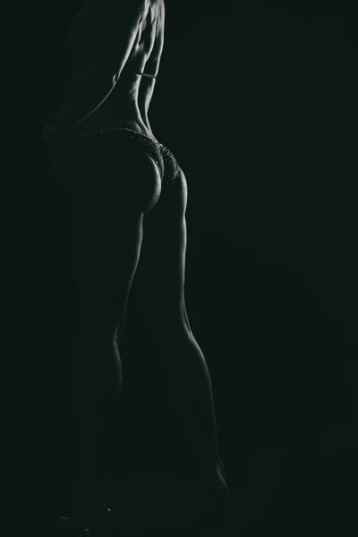 Elegant training, muscular woman on a black background — Stock Photo, Image