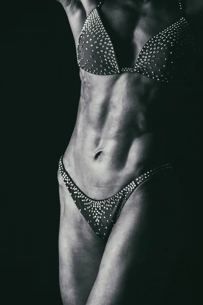 Элегантная тренировка, мускулистая женщина на черном фоне — стоковое фото