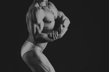 Karanlık bir arka plan üzerinde vücut geliştirmeci.