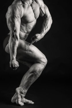 Karanlık bir arka plan üzerinde vücut geliştirmeci.