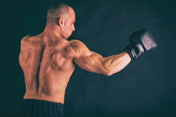 Corpo masculino muscular em um fundo escuro . — Fotografia de Stock