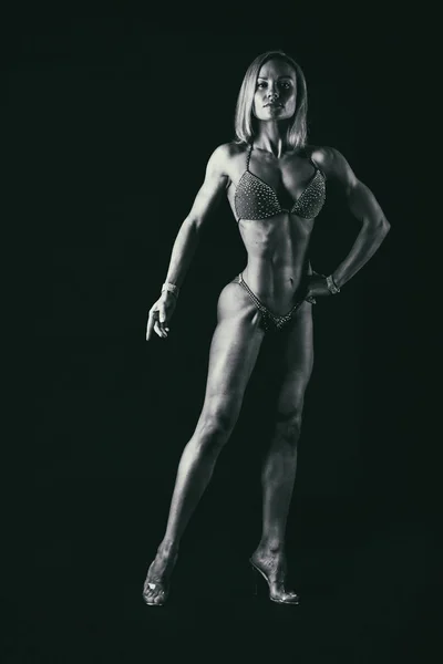 Vrouw bodybuilder op zwart — Stockfoto