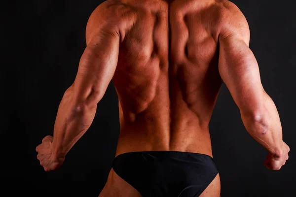 Bodybuilder poseren op zwart — Stockfoto
