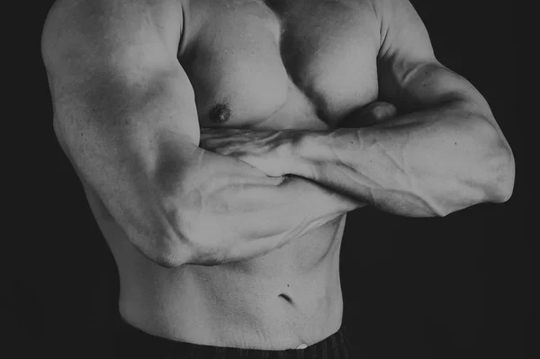 Muscoloso corpo maschile su uno sfondo scuro . — Foto Stock